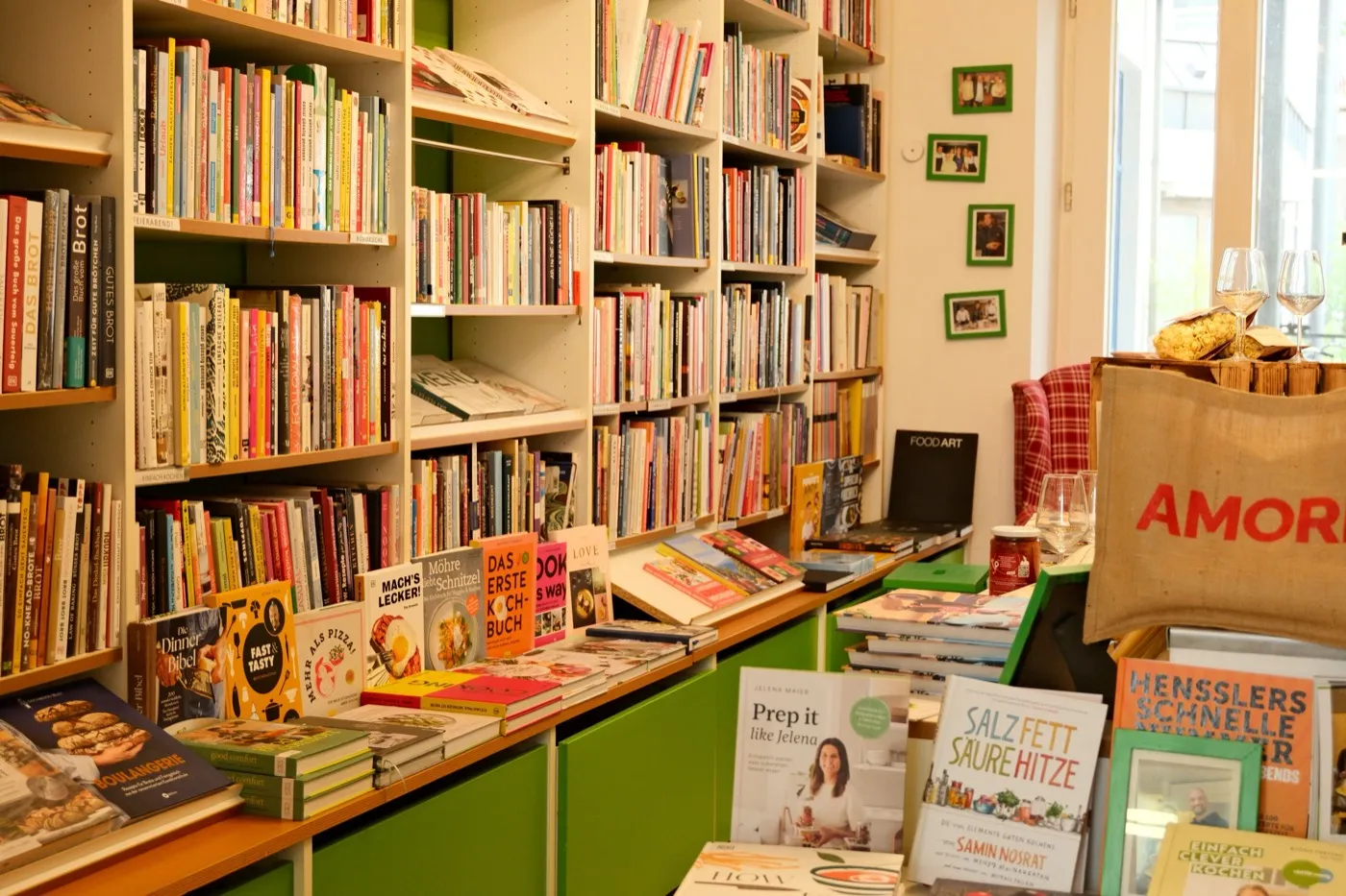 Buchhandlung mit vollen Regalen und einem Tisch voller ausgelegter Bücher.