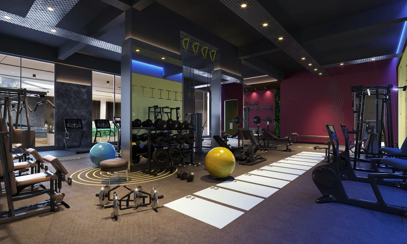 Sala de un gimnasio con mancuernas, fitballs y máquinas.