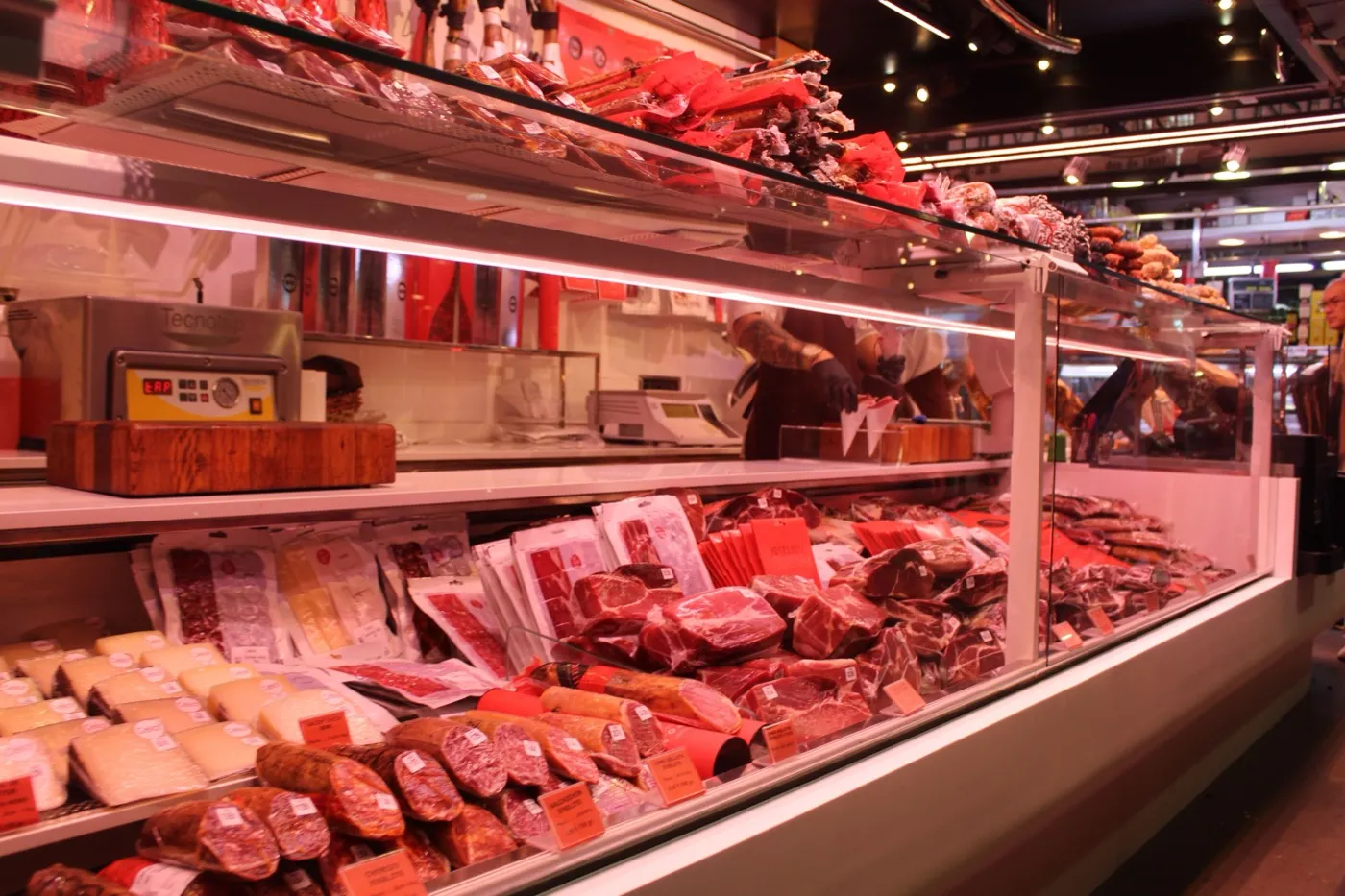 La vitrine réfrigérée d’une boucherie remplie de saucisses, de viande et de fromage.